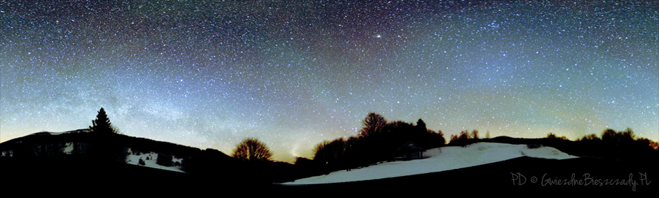Na zdjęciu po środku widoczne pasy światła typu „airglow” lub „niebieską poświatą”. W środkowej części kadru widoczny jaśniejszy „obłok” to tzw. przeciwblask - część światła zodiakalnego. To międzyplanetarny pył, na którym rozprasza się słoneczne światło. W lewej części kadru widoczna Droga Mleczna. Zdjęcie wykonane parkingu na Przełęczy Wyżniańskiej pod Małą Rawką nad ranem 18 marca.2013. Fot. Pavol Ďuriš / Park Gwiezdnego Nieba „Bieszczady” © 2013